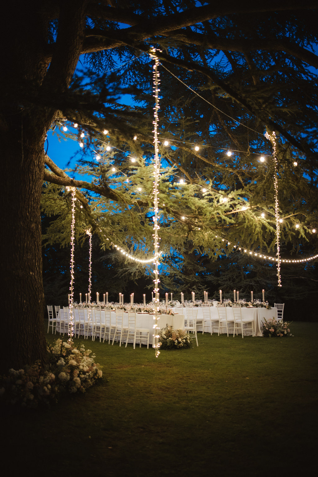 A candlelit wedding reception beneath a tree at Borgo Laticastelli