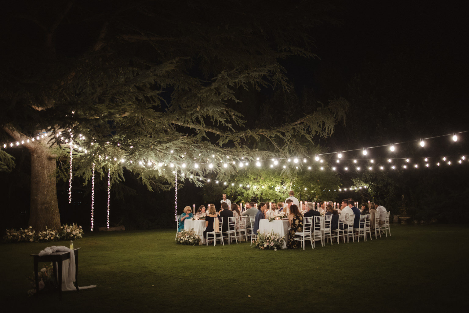 A wedding celebration beneath string lights at Borgo Laticastelli